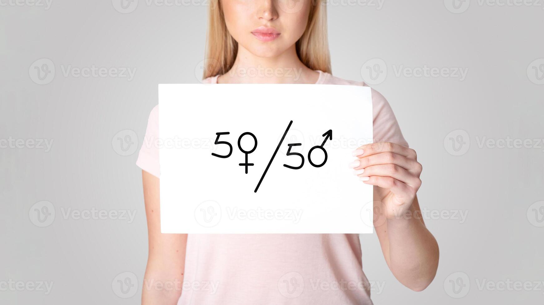 A woman holds up a sign displaying a 50 and 50 symbol, representing equality in marriage. This moment highlights discussions on domestic violence and relationship dynamics among millennials. photo