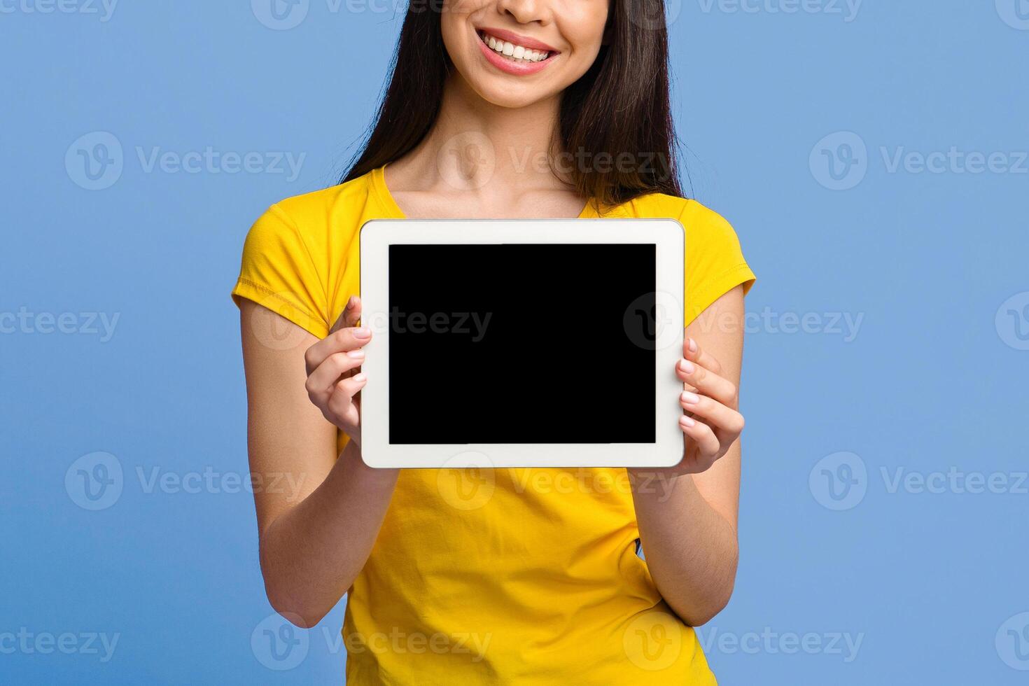 Mockup image of digital tablet with black screen in hands of unrecognizable brunette girl, purple background, copy space photo