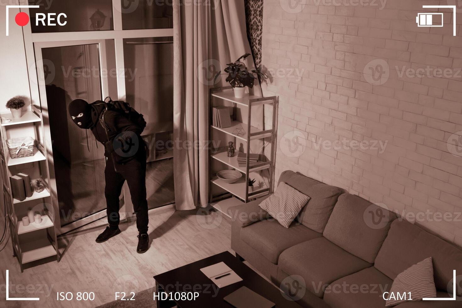 Surveillance Concept. Thief With Crowbar Wearing Balaclava Entering House, Scene Through CCTV Camera, High Angle View photo