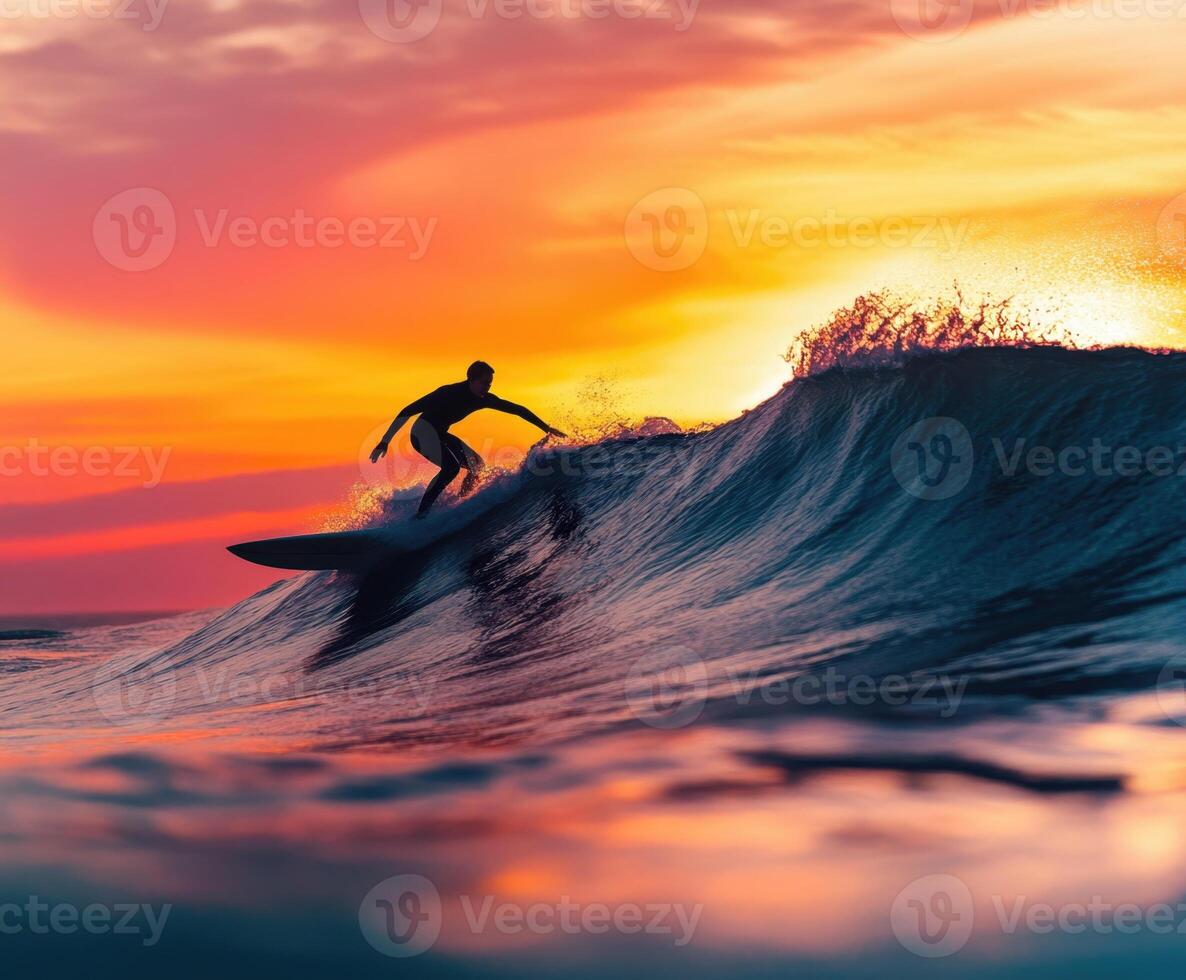 Surfer riding a wave at sunset on a calm ocean photo