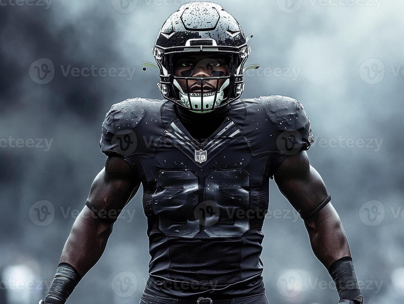 Strong football player in black uniform preparing for game photo