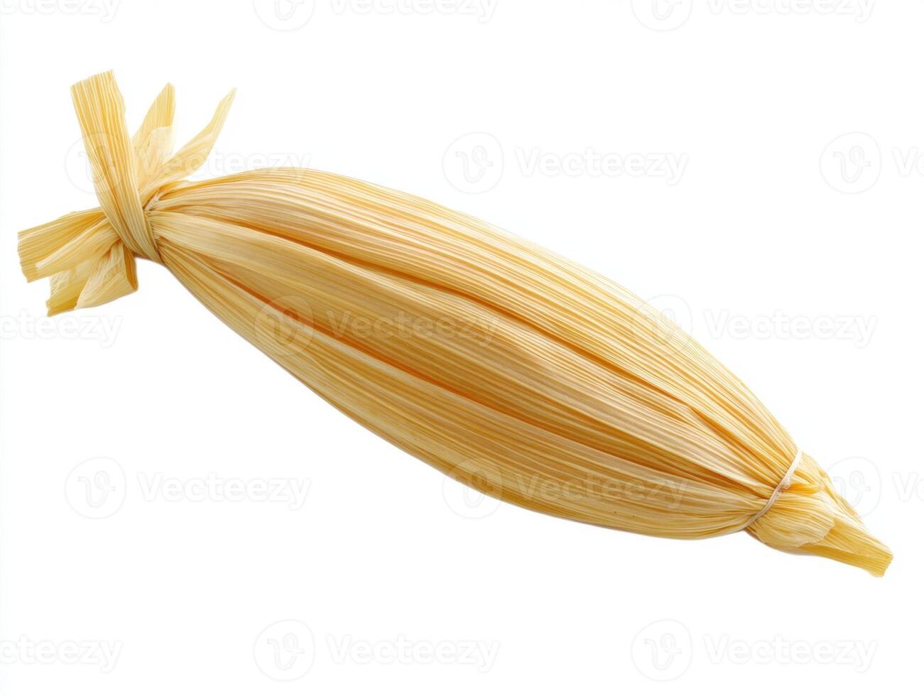 Traditional tamale wrapped in corn husk prepared for cooking photo