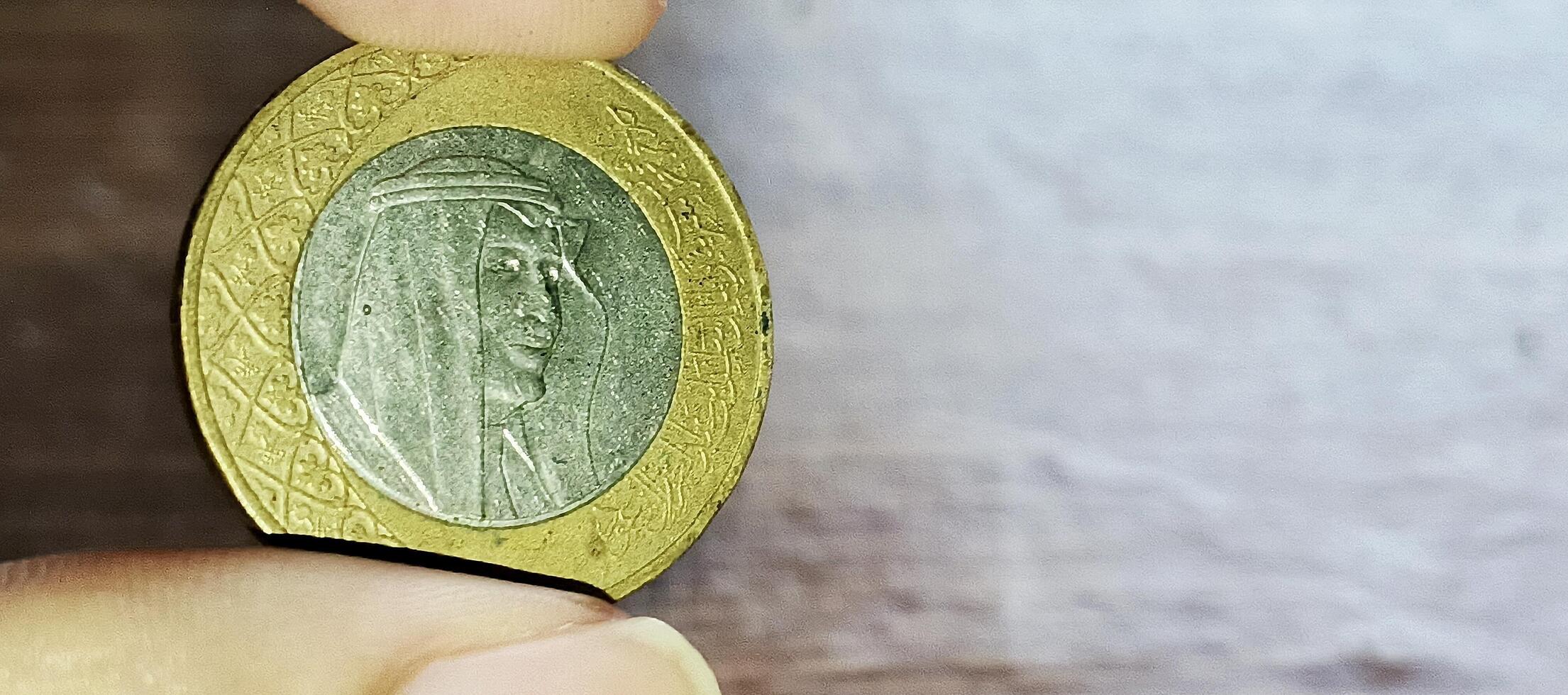 A person holding a coin with a picture of a man on it photo