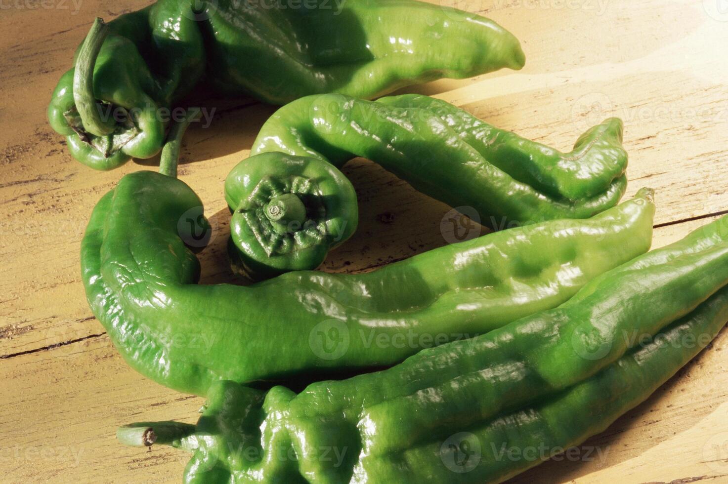 A bunch of green peppers sitting on a table photo