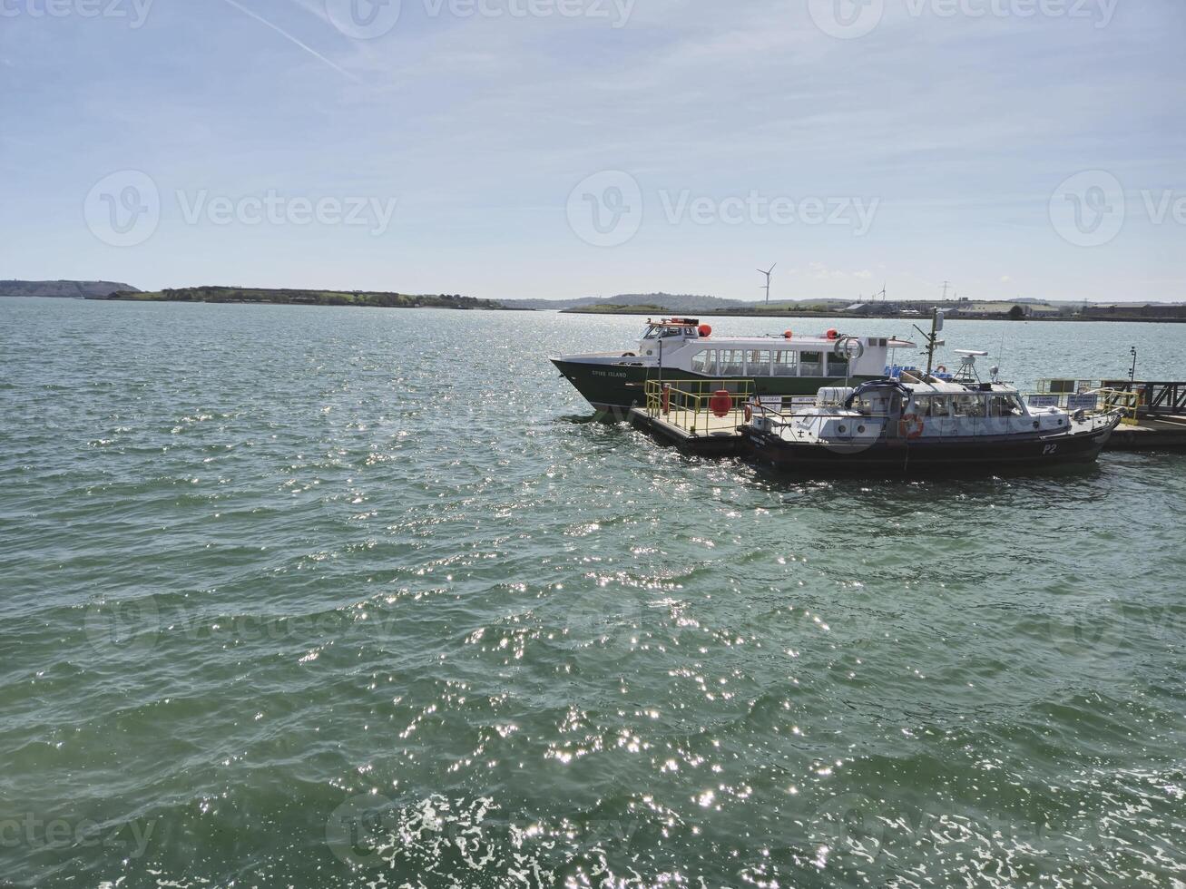 A boat is docked at a dock in the water photo