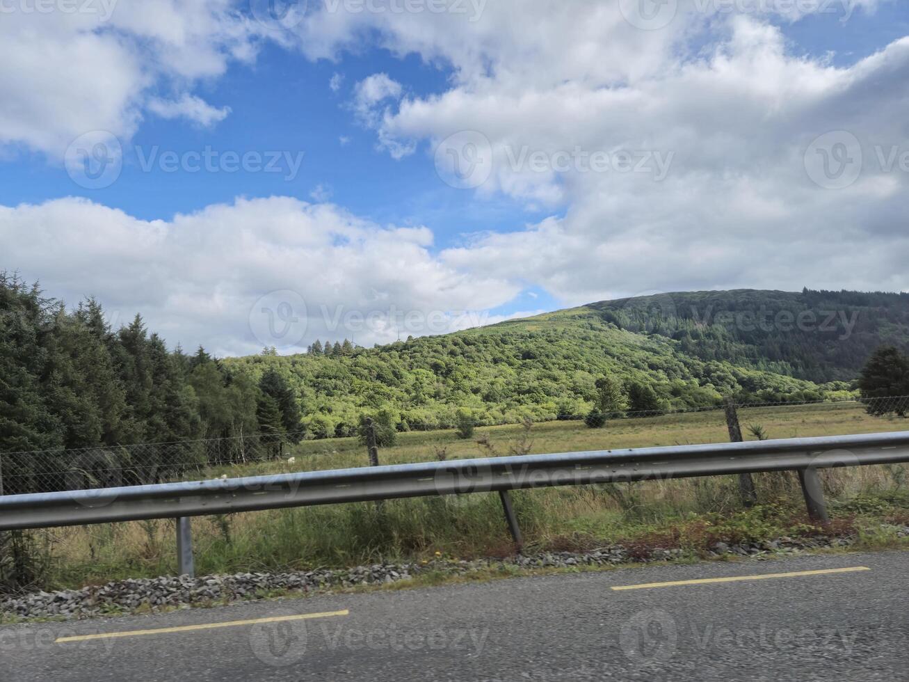 A car driving on a road with a hill in the background photo