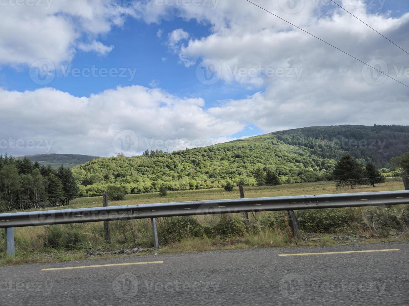 A view of a road with a hill in the background photo