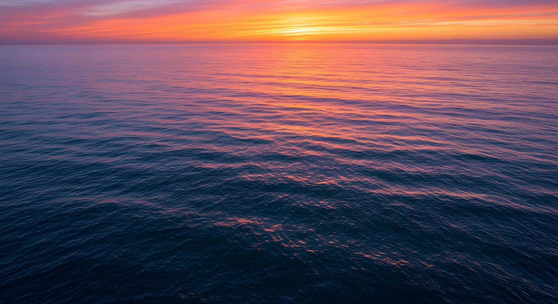 Ocean at Sunset with Vivid Sky Colors and Gentle Wave Ripples photo