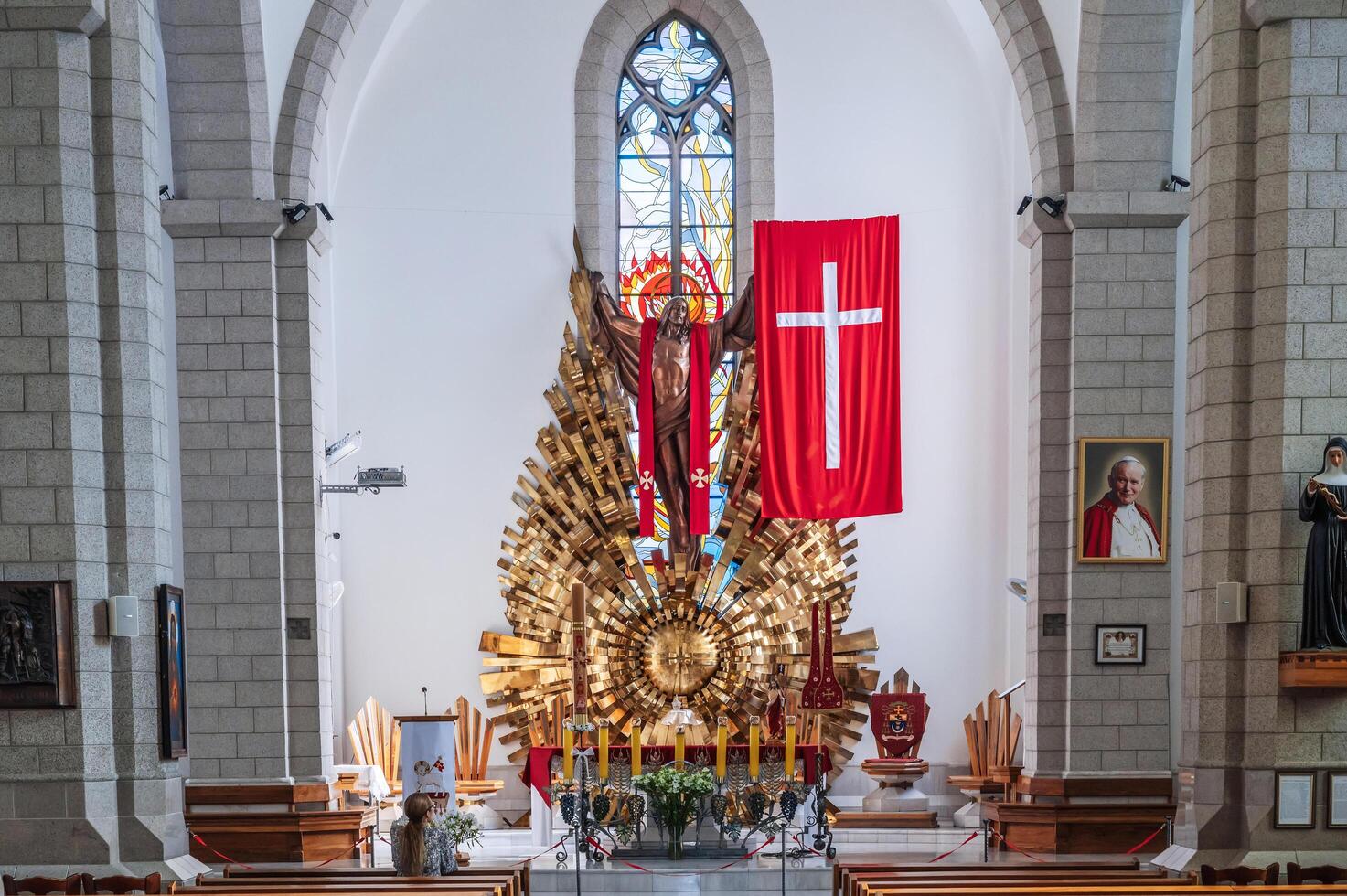 Altar with Jesus Christ and a cross in interior of a white Christian Catholic church. Cathedral of Sacred Heart of Jesus. Tashkent, Uzbekistan - April 18, 2024 photo