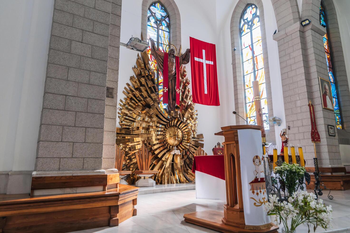 Altar with Jesus Christ and a cross in the interior of a white Christian Catholic church. Cathedral of Sacred Heart of Jesus. Tashkent, Uzbekistan - April 18, 2024 photo