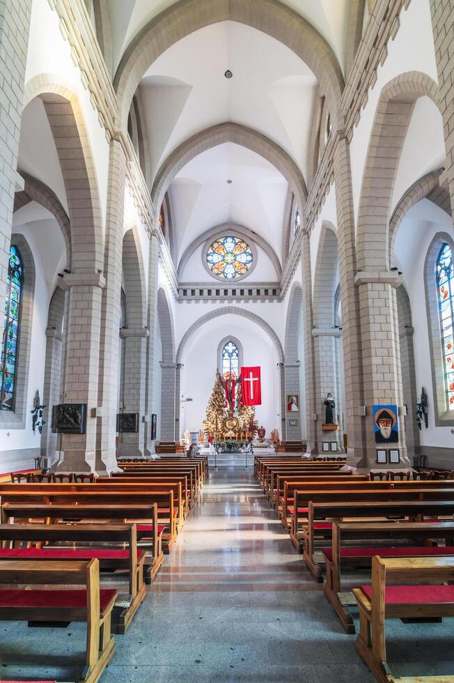 Interior of Christian Catholic church with benches. Sacred Heart of Jesus Cathedral. Tashkent, Uzbekistan - April 18, 2024 photo
