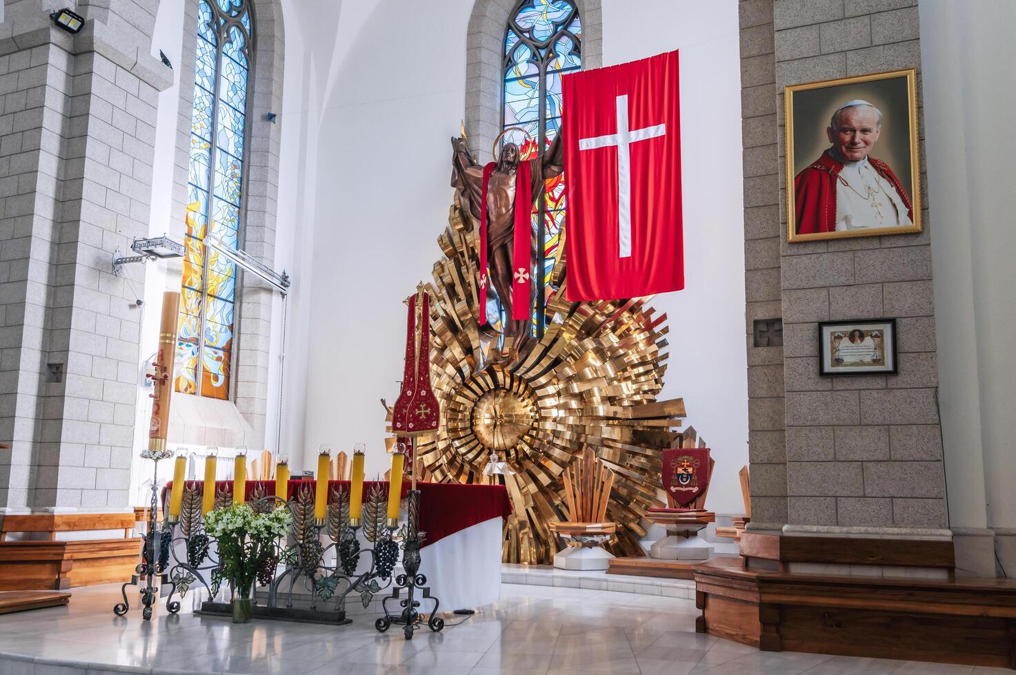 Altar with Jesus Christ and a cross in the interior of a white Christian Catholic church. Cathedral of Sacred Heart of Jesus. Tashkent, Uzbekistan - April 18, 2024 photo