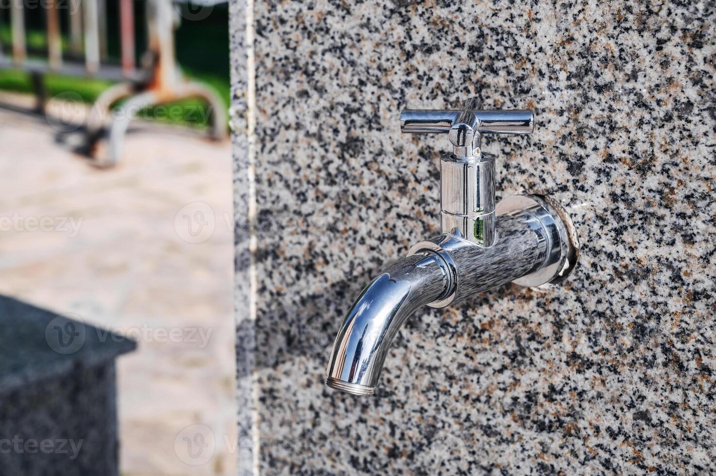 modern metal outdoor faucet with clean drinking water in park on the street in the city in summer photo