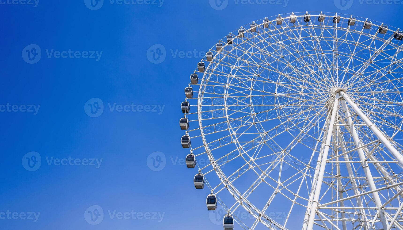 white big Ferris wheel on background a bright blue sky in amusement park at fair in summer with copy space photo