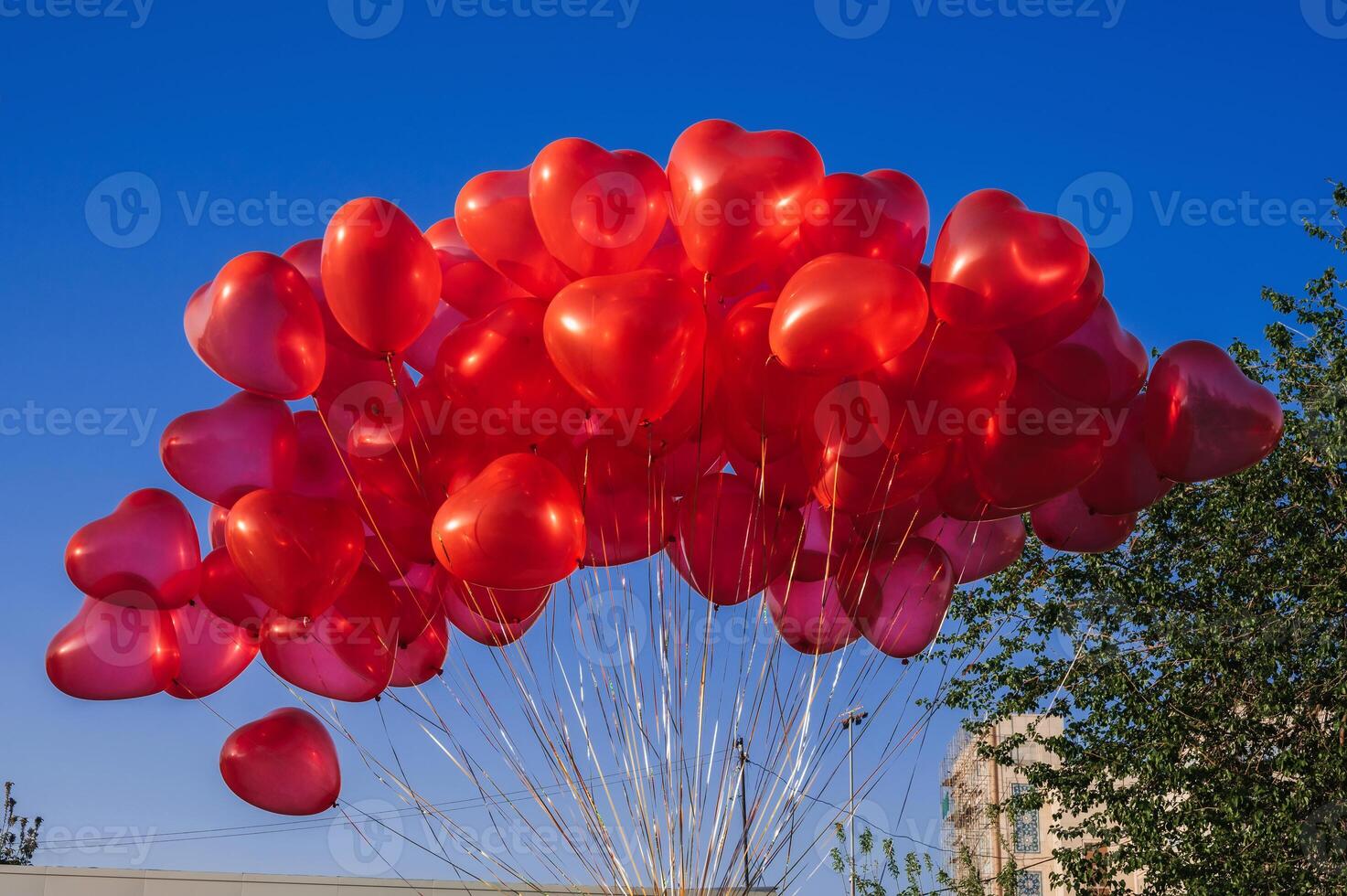 many red balloons in shape of a heart on the background of blue sky photo