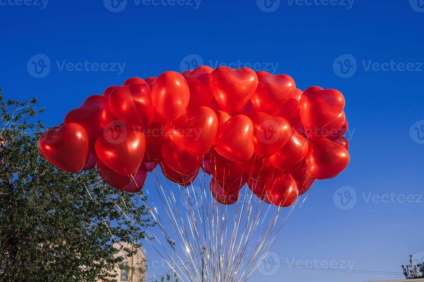many red balloons in shape of a heart on the background of blue sky photo