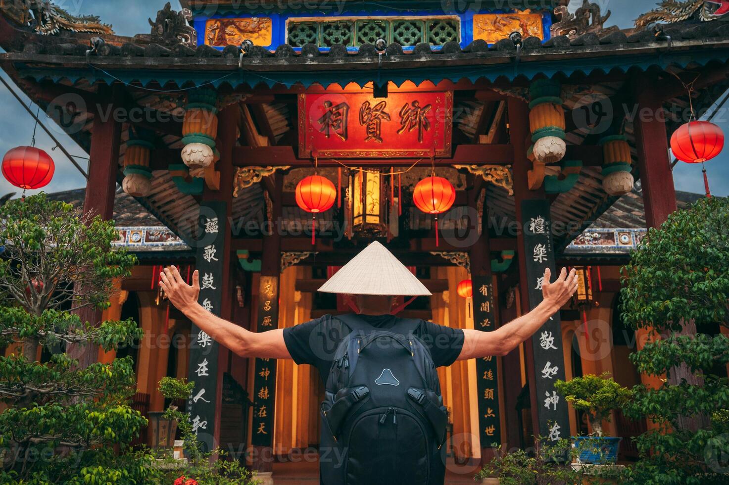back of man tourist in a Vietnamese hat at pagoda in Hoi An in Vietnam in Asia photo