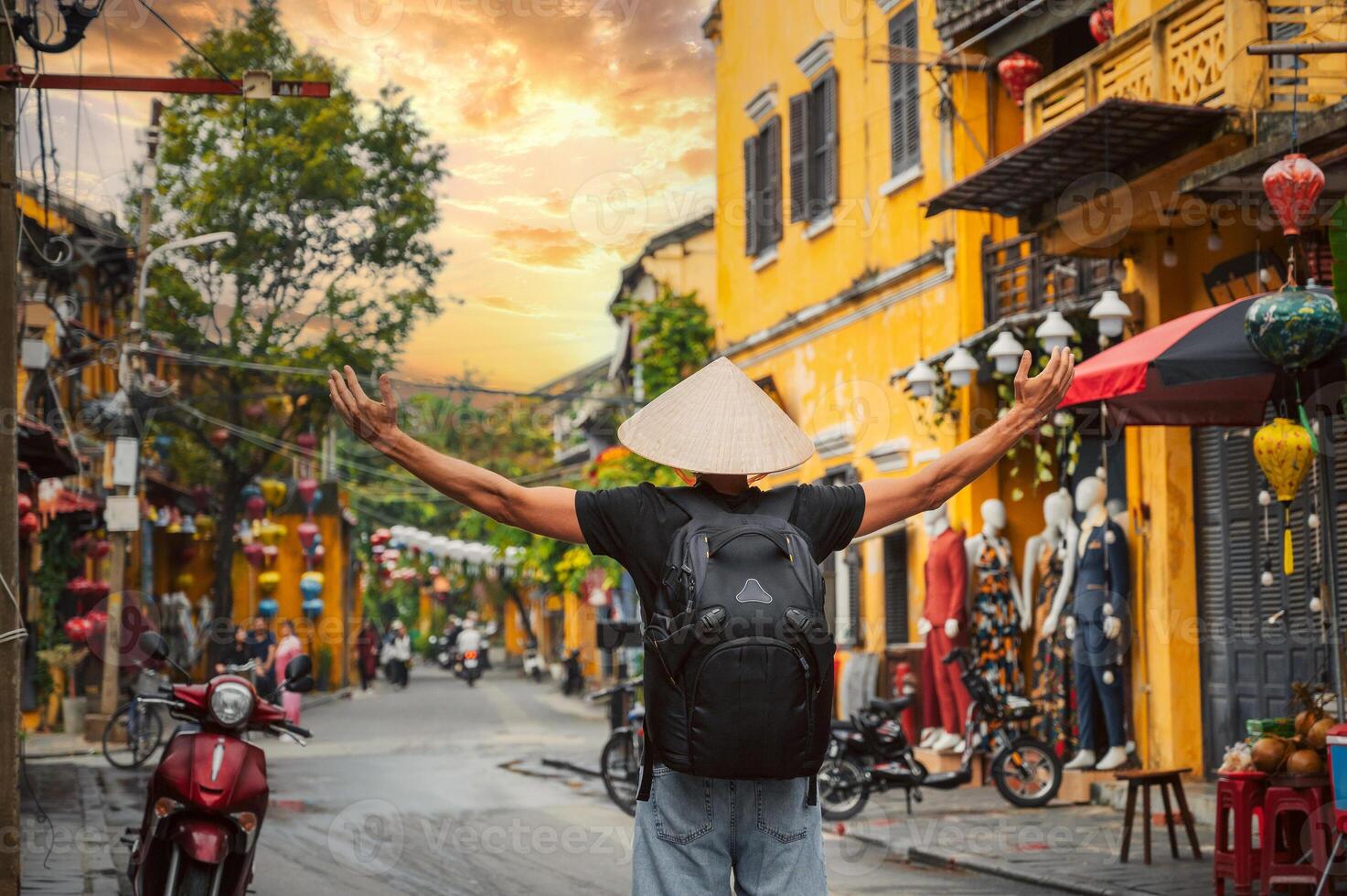 Asian male traveler tourist in traditional vietnamese Non La hat on street in old town in Hoi An city in Vietnam in Asia photo