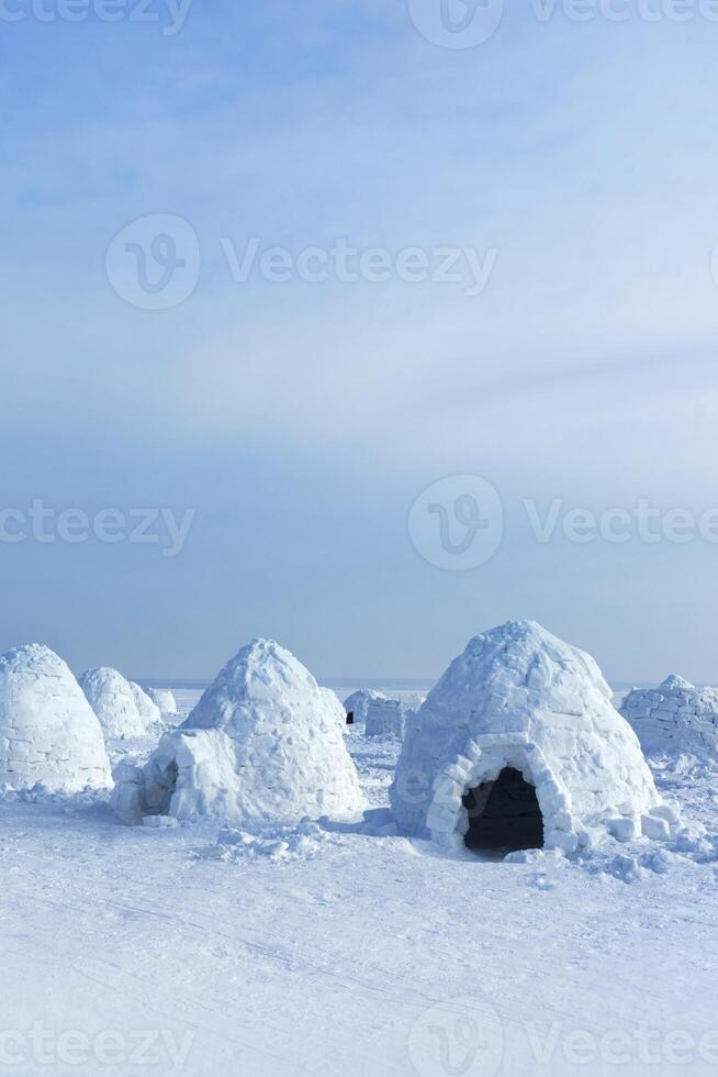Igloo holiday. Eskimo dwelling made of ice and snow. Lots of igloo built, Vertical photo