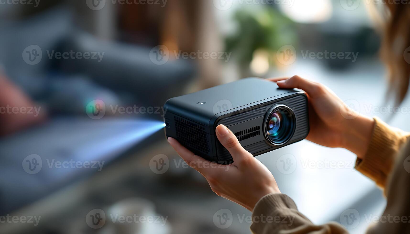 A person holding a small projector in their hand photo