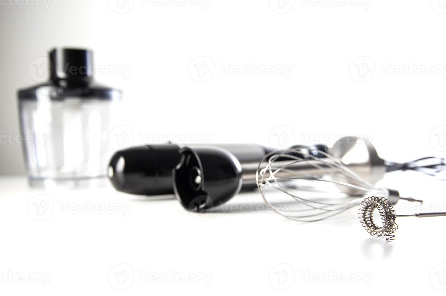 Modern set for immersion blender with whisk, milk frother and bowl on white background. Modern household appliances, close-up. Copy space for text photo