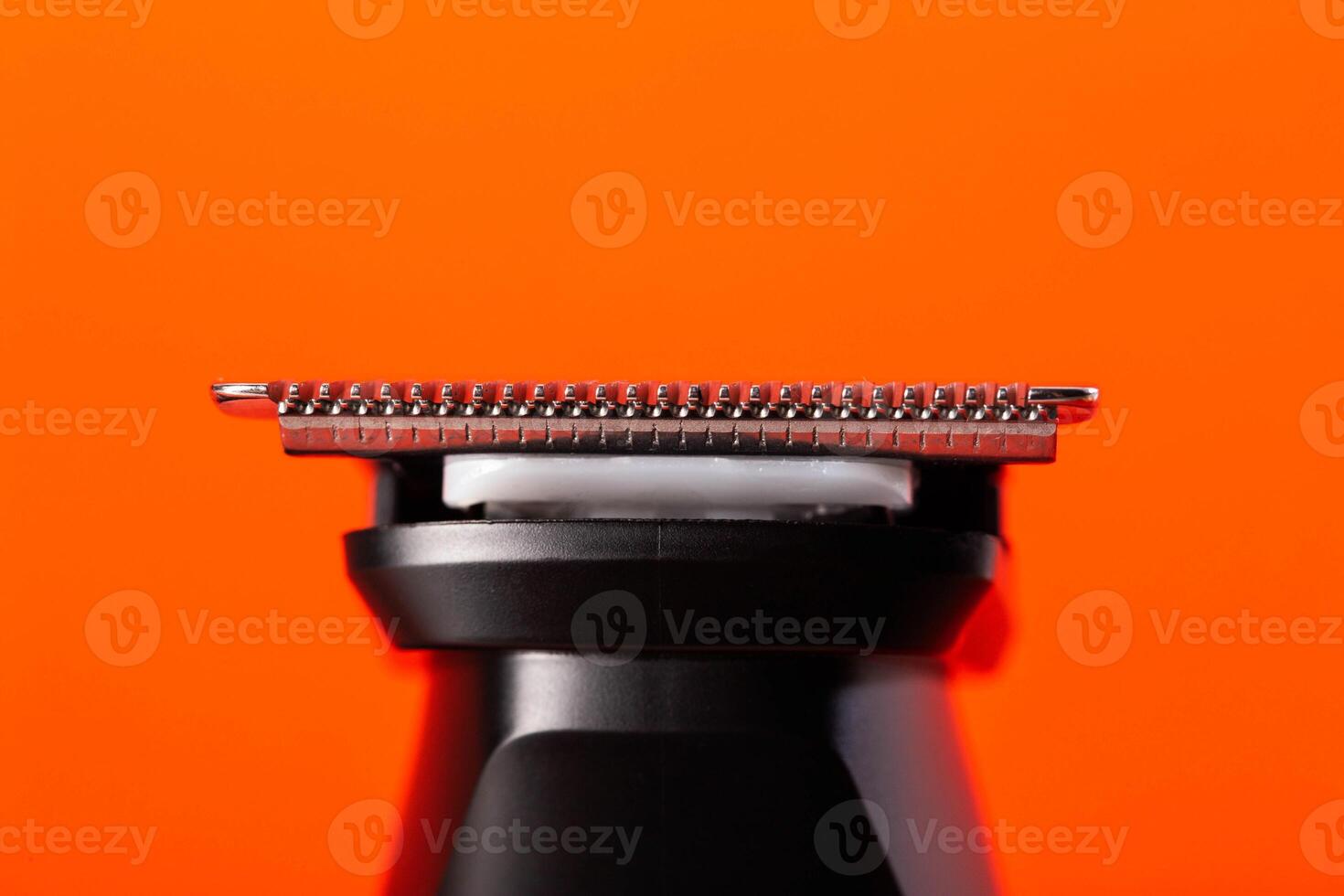 beard trimmer on a red background, close-up. Hair and beard care photo