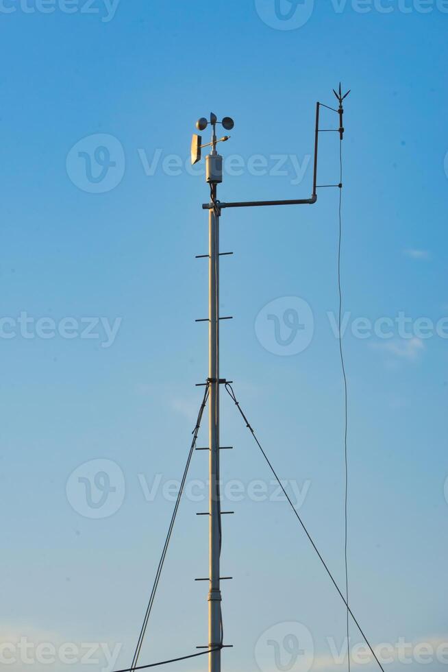 Weather monitoring station captures atmospheric data under clear blue sky photo