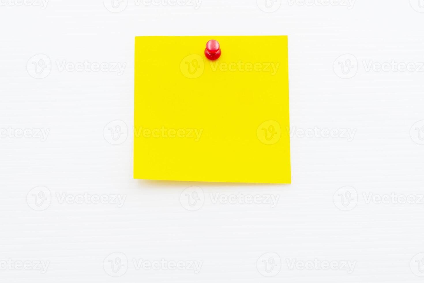 Bright yellow post note paper pinned on a white wall for reminders or messages photo