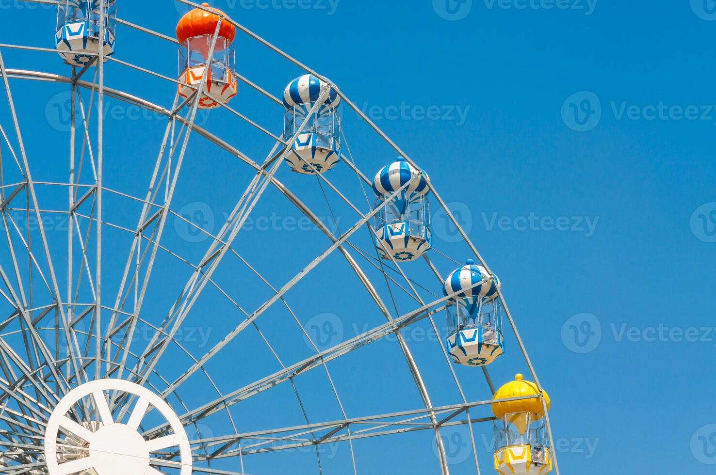 Colorful ferris wheel against a clear blue sky during a sunny day photo