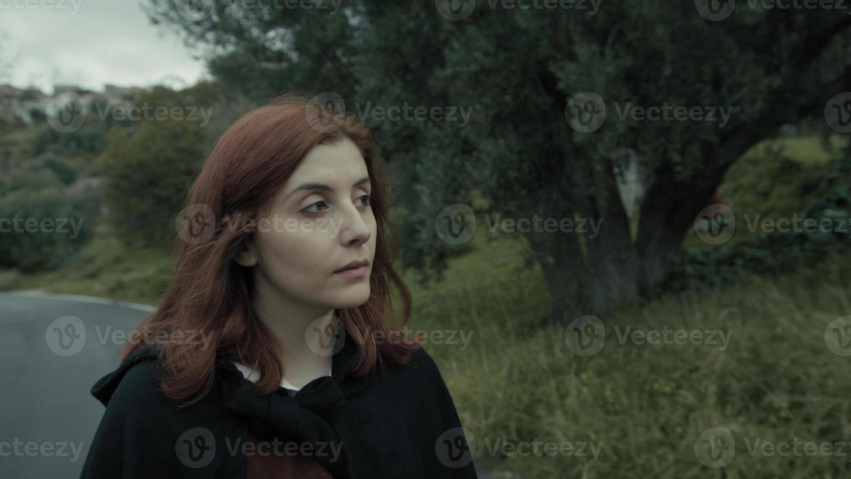 Young Woman Relaxedly Walks and Breathes Pure Air on a Mountain Road photo