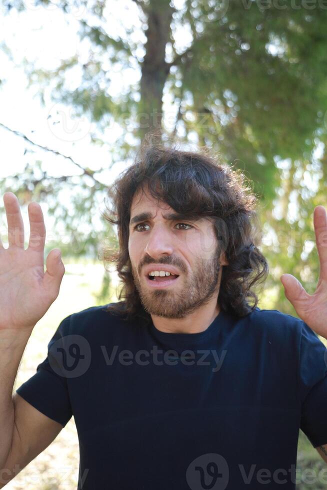 Scared Boy Raises His Hands Before Receiving Theft From A Criminal In a Park photo