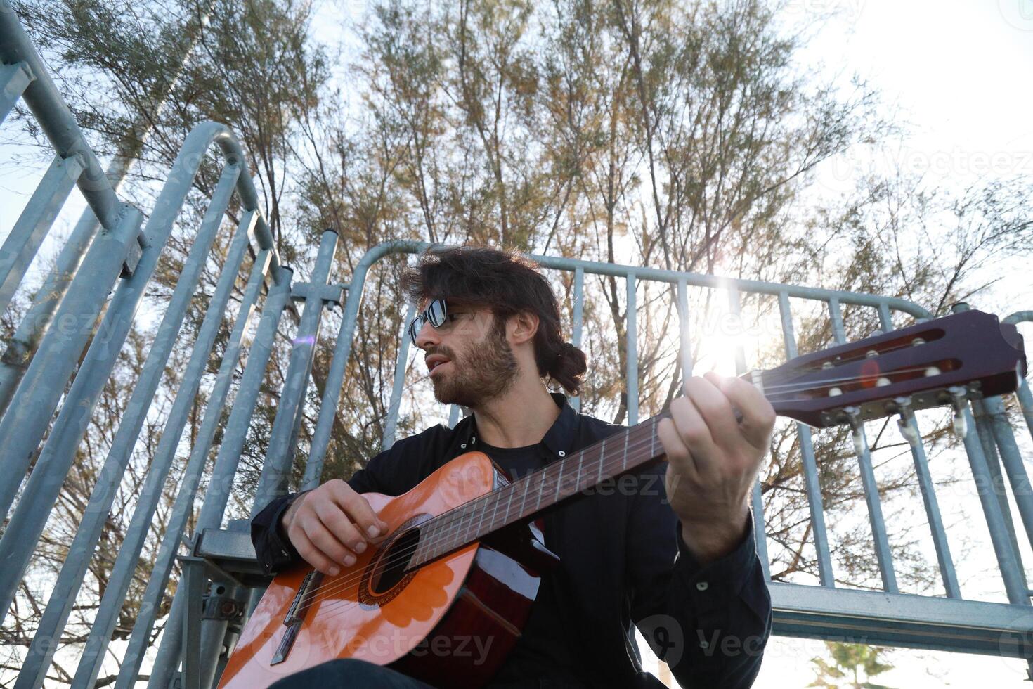 Man Plays Music With Classical Guitar Inexpensive Instrument photo