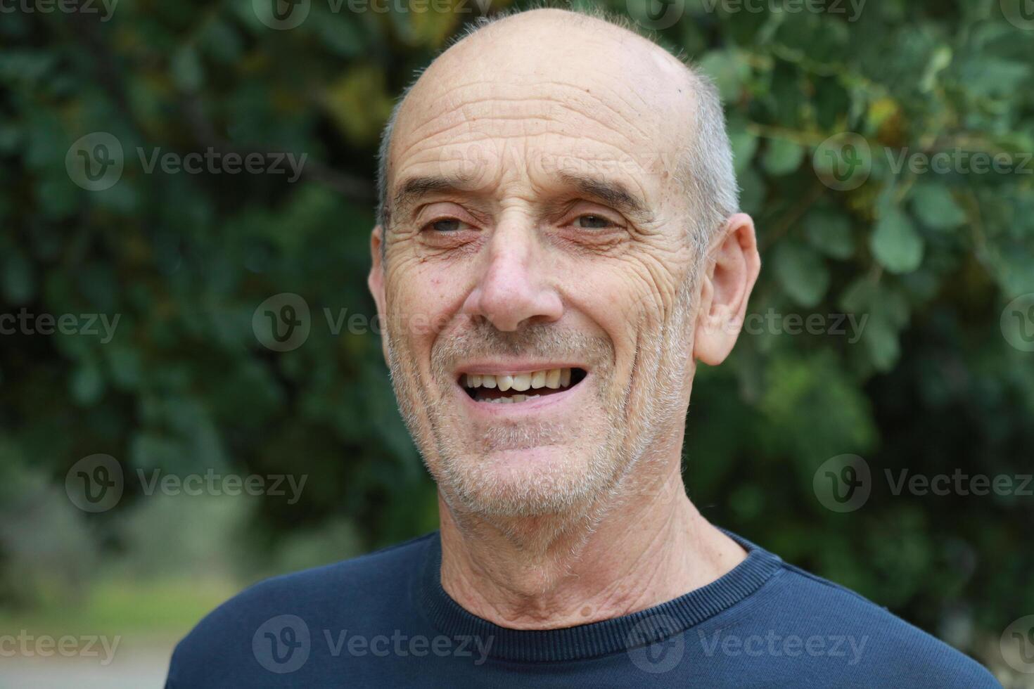 Elderly Man Smiles Talking With His Friend In The Natural Park photo