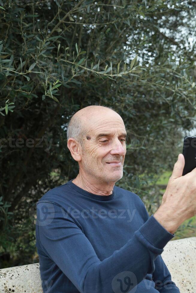 Elderly Man Makes Call In His Countryside Outdoors And Talks On The Phone photo