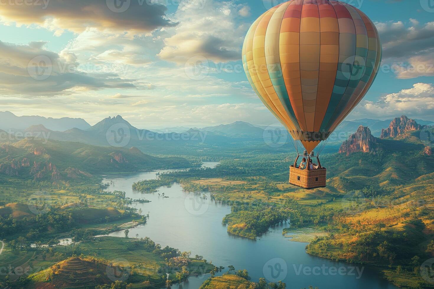 Colorful hot air balloon floats over a stunning landscape of rivers and mountains at sunset. photo