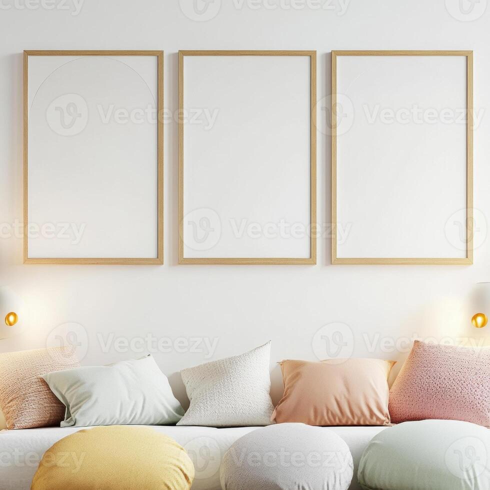 Minimalist living room with pastel cushions and three wooden-framed blank canvases on the wall. photo