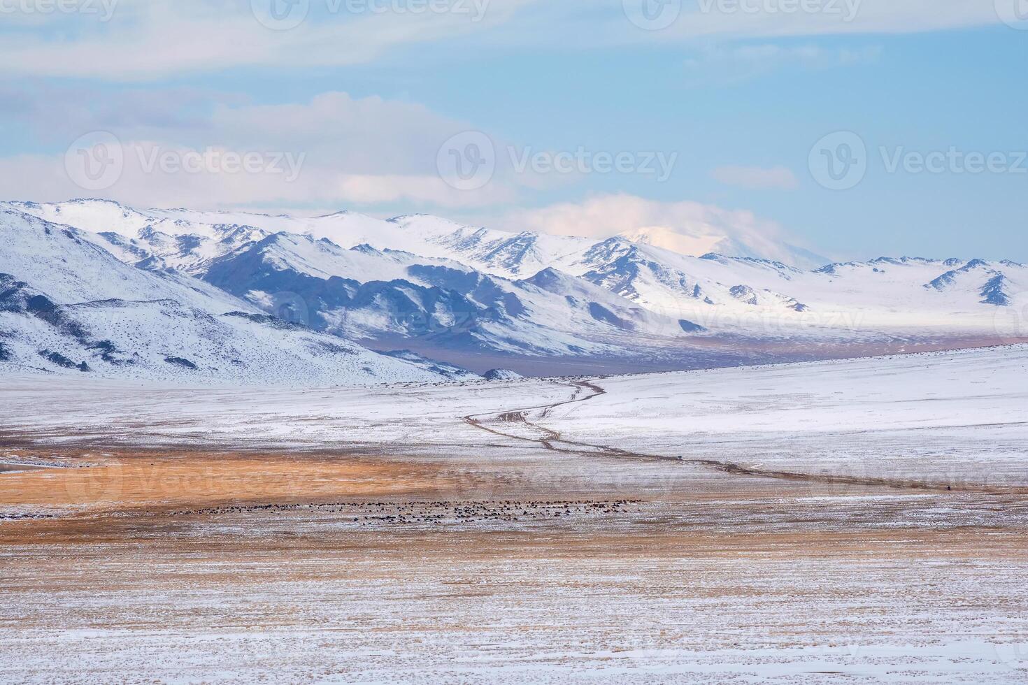 Long road through a snowy plateau to the mountains. photo