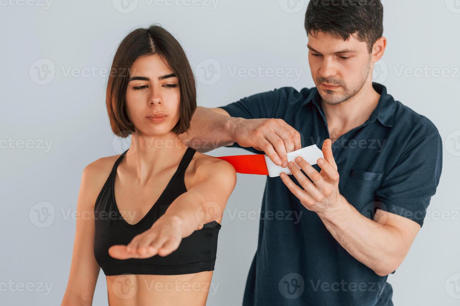 Focused worker. Woman visiting physiologist that putting kinesio tape on the skin, photo