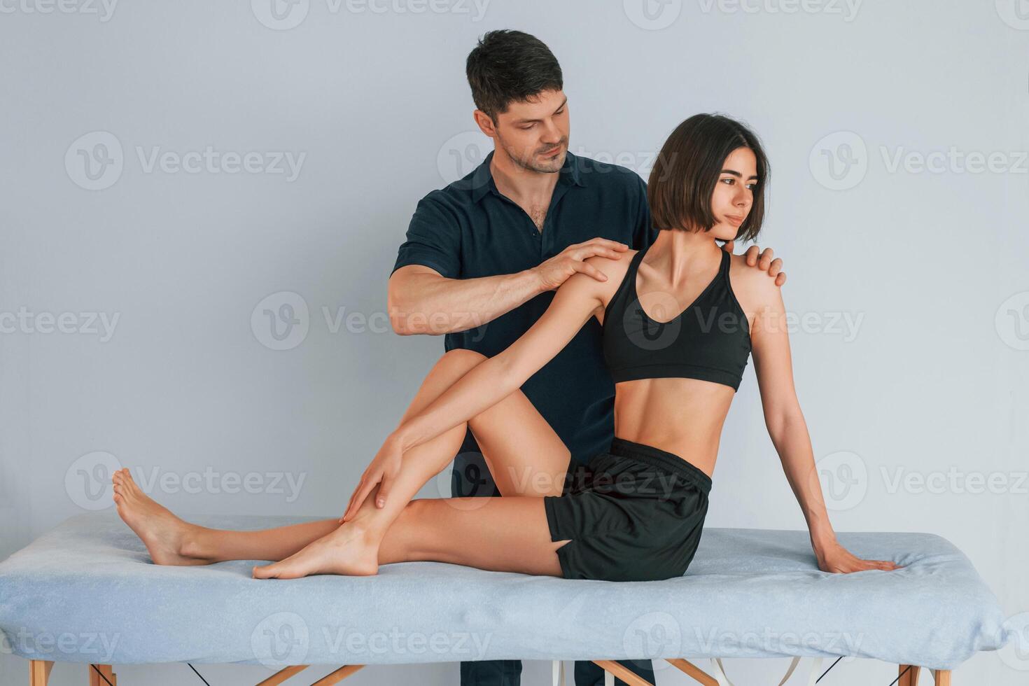 Grey colored background.. Woman visiting physiologist that making massages and helping with traumas photo