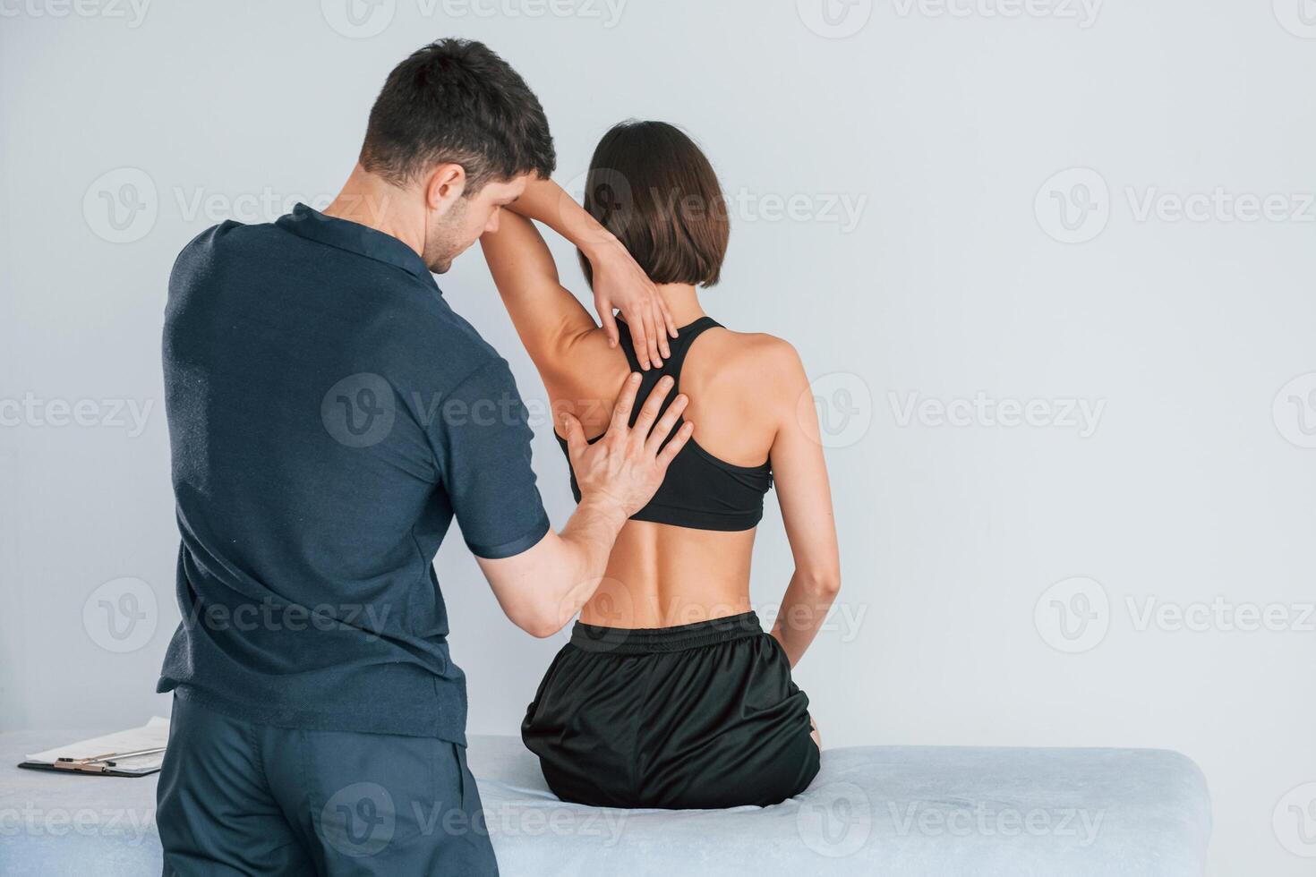 Sitting on the table. Woman visiting physiologist that making massages and helping with a traumas photo