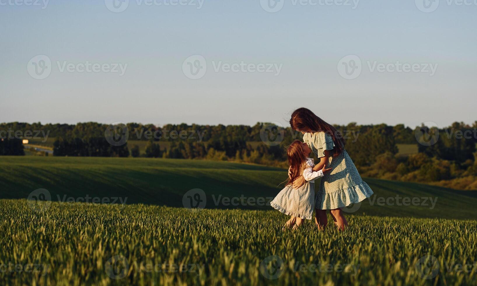 Little girl is running to the woman.. Mother and daughter have fun outdoors on the field at summer photo