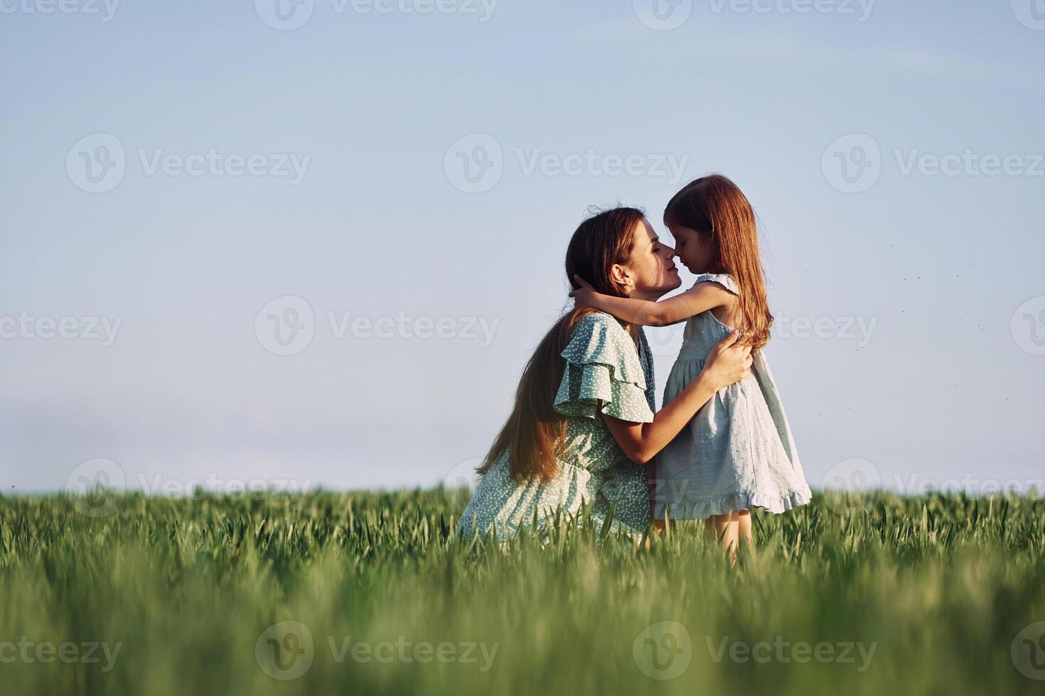Moment of tenderness. Mother and daughter have fun outdoors on the field at summer.., photo