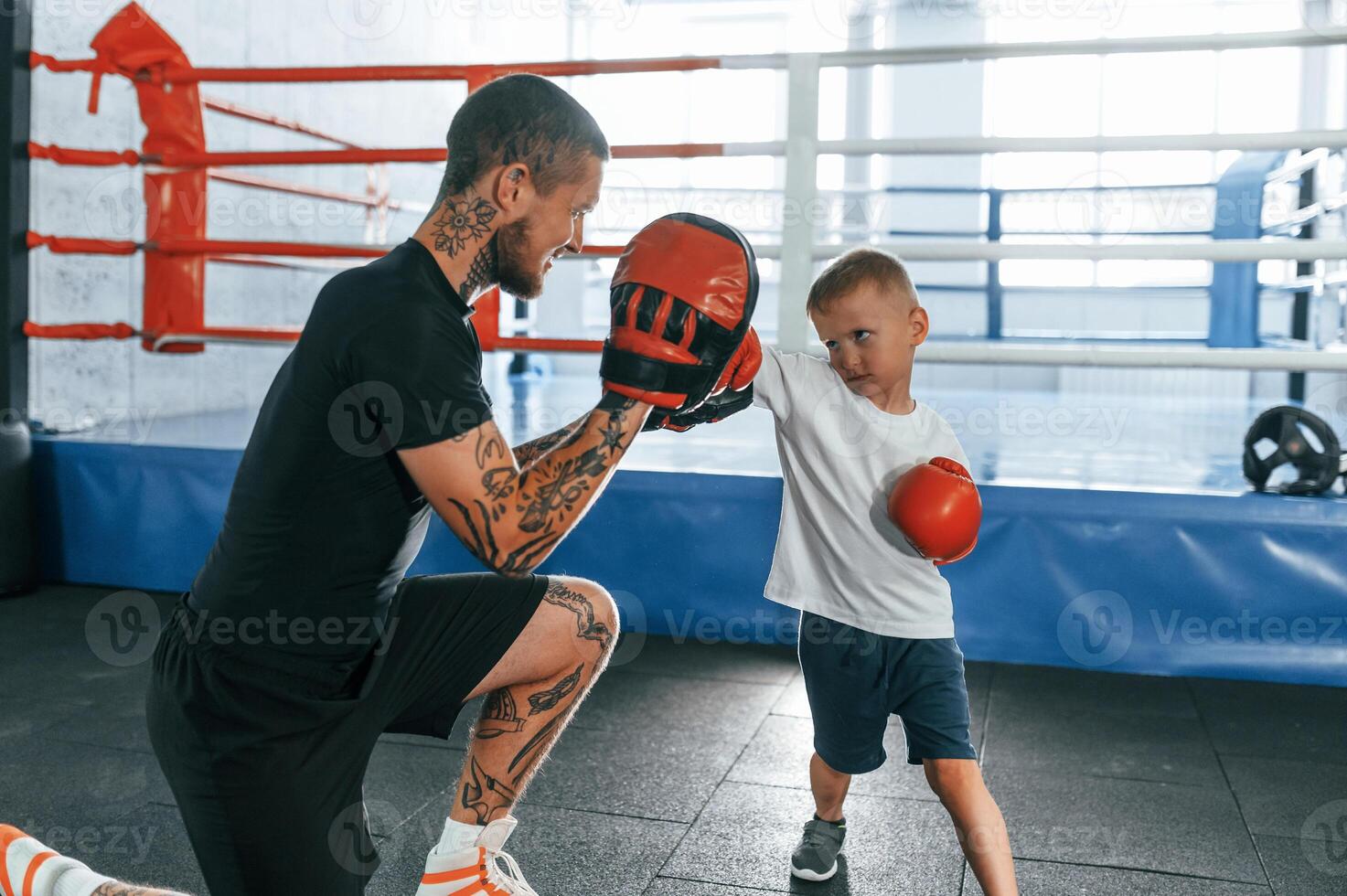 Teaching how to punch. Coach is with boy showing box techniques indoors photo