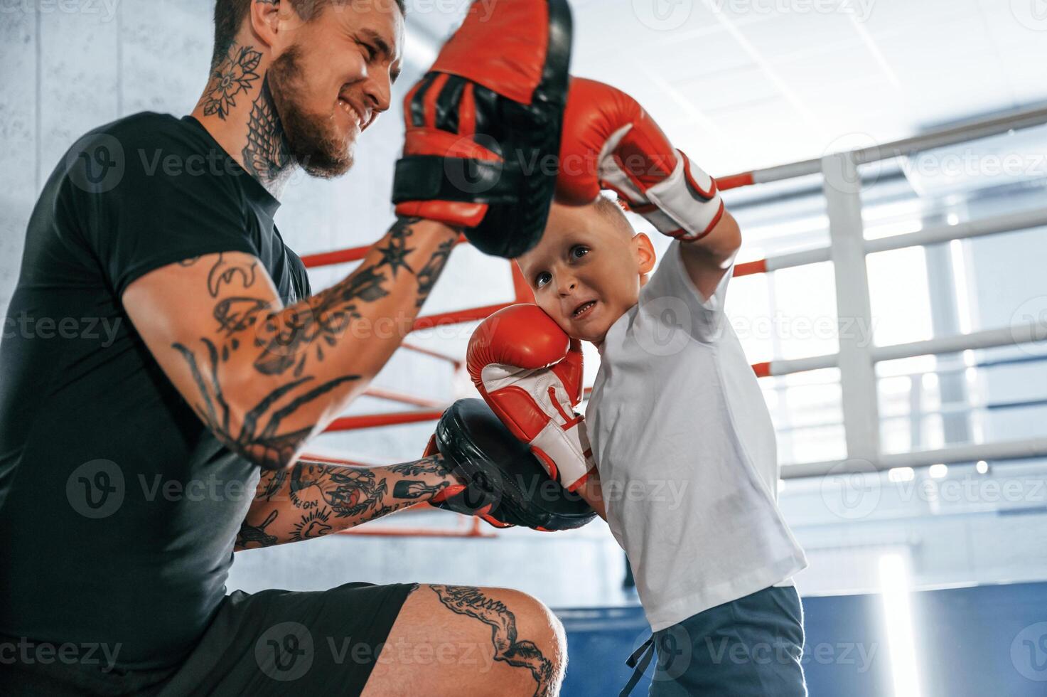How to punch correct way,. Coach is teaching the boy box techniques indoors photo