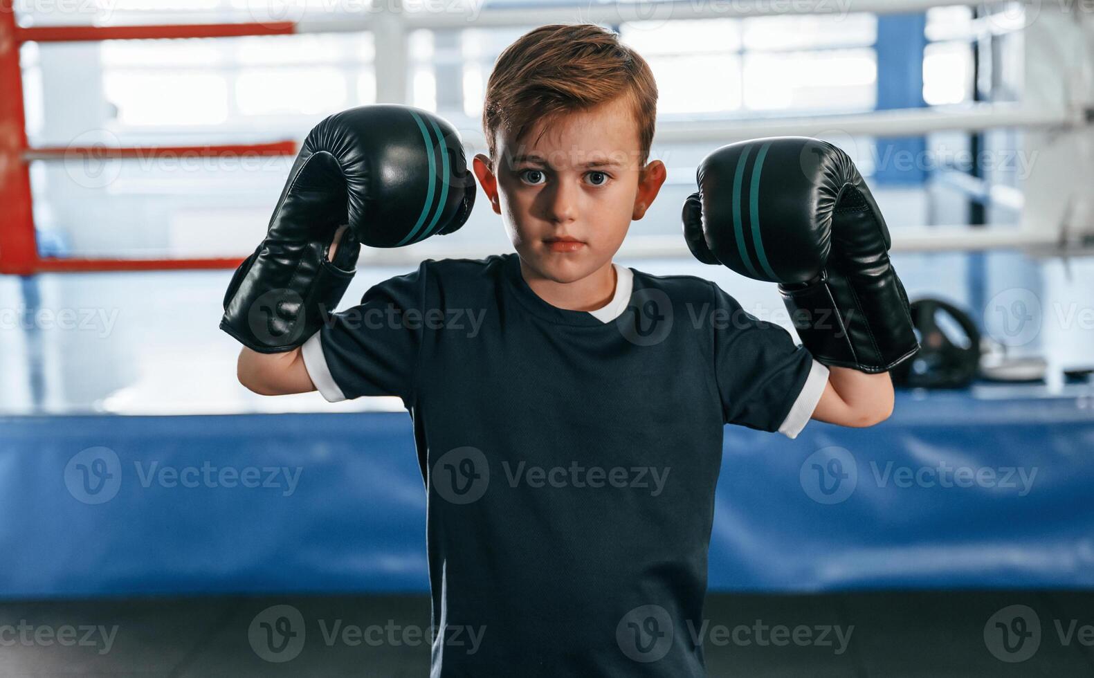 Boy is practicing boxing in the gym with glowes on hands photo