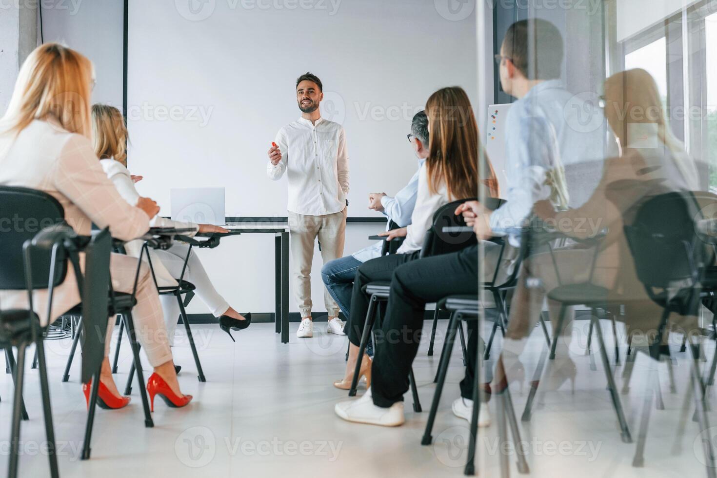 Man is teaching and making master class.. Group of professional business people is in the office photo