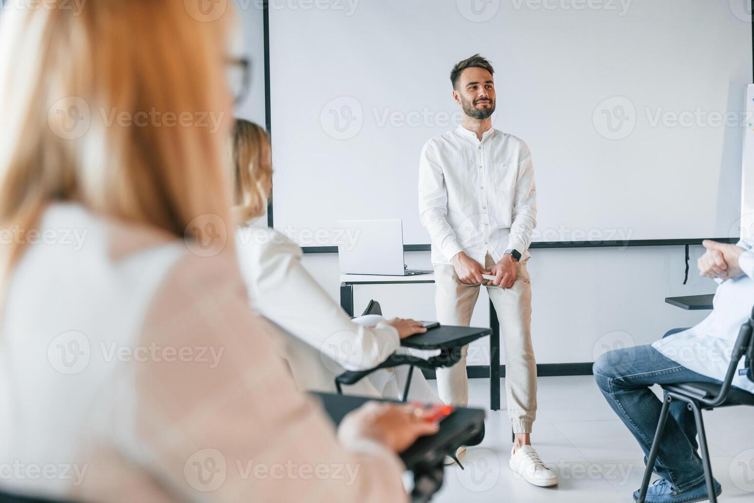 Man is teaching and making master class., Group of professional business people is in the office photo