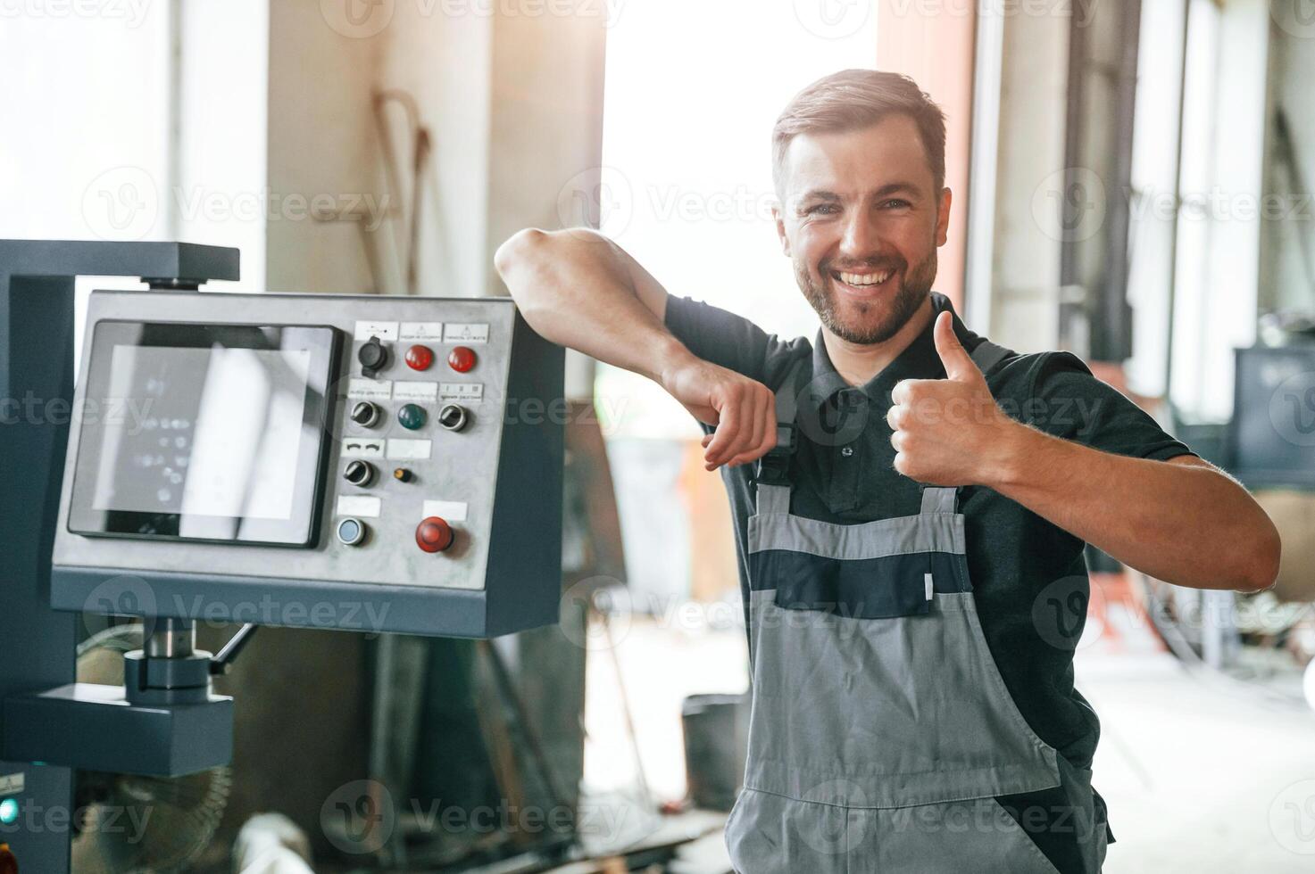 Standing, near operate device. Man in uniform is in workstation developing details of agriculture technique photo