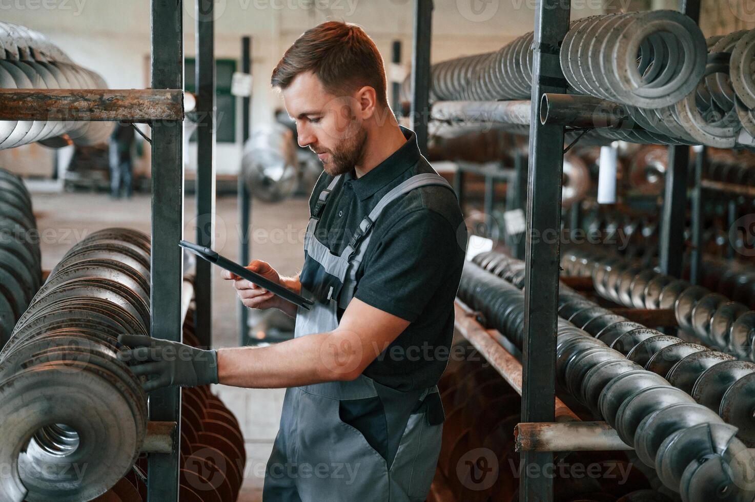 Checking details. Man in uniform is in workstation developing details of agriculture technique.. photo