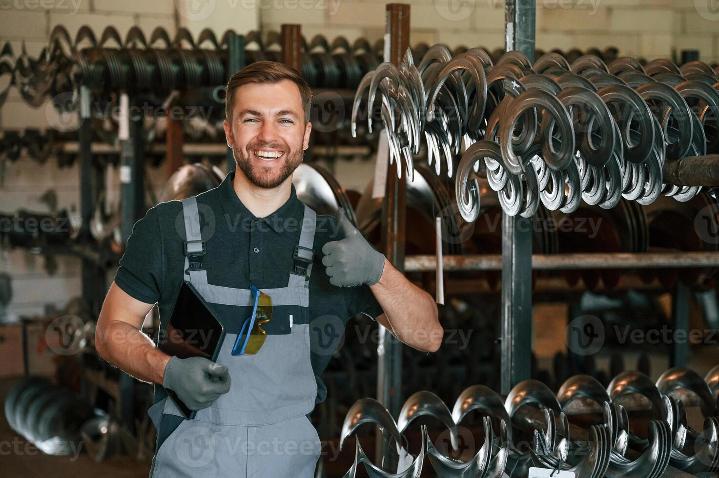 Grey uniform.. Man is in workstation developing details of agriculture technique photo